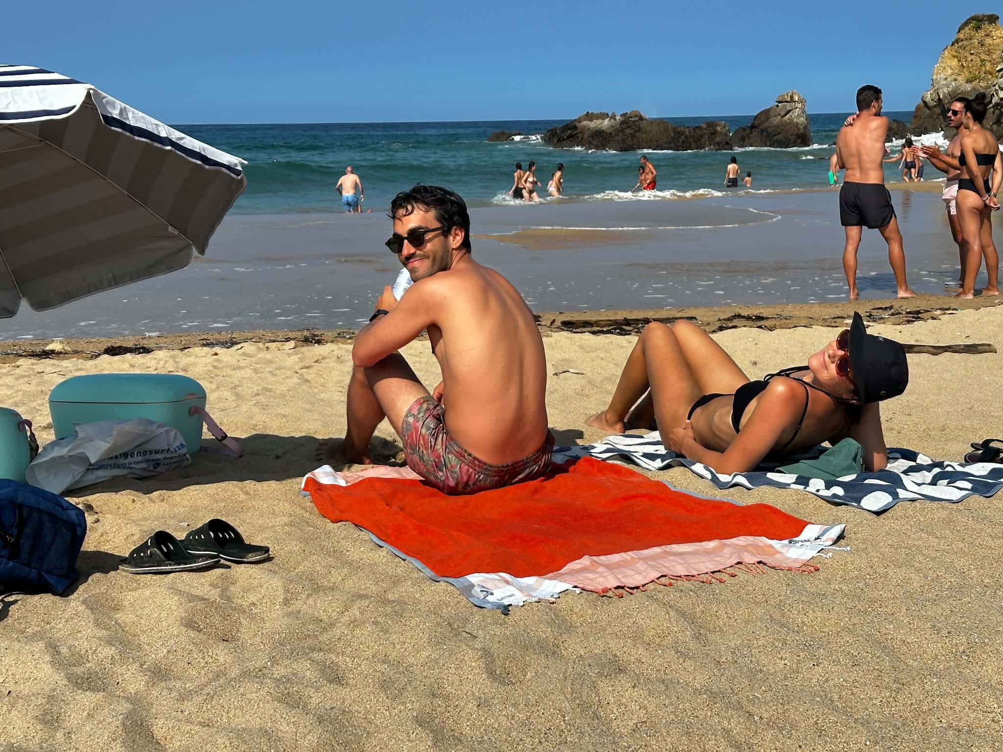 Charlotte et Ignacio sur leurs serviettes, sur une plage galicienne