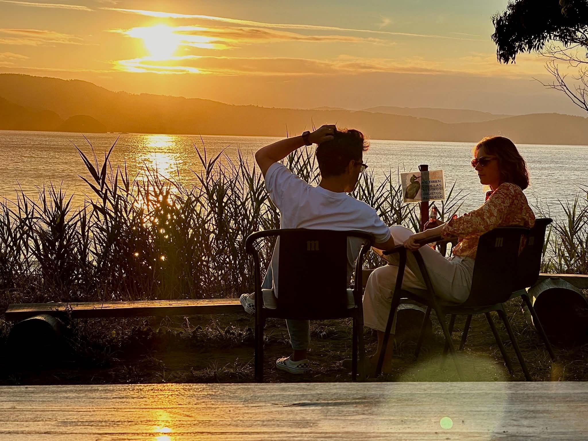 Charlotte et Ignacio assis face à la ria au coucher du soleil